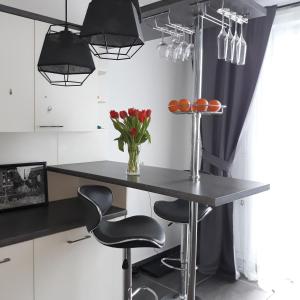 eine Küche mit einem Tisch, 2 Stühlen und Lampen in der Unterkunft Modern Calm Studio, Wroclaw in Breslau