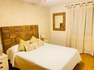 1 dormitorio con cama blanca y espejo en Chinchonspa, en Chinchón