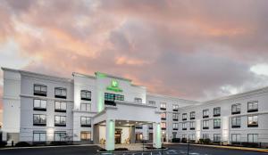 a white building with a green sign on it at Holiday Inn Allentown-Bethlehem, an IHG Hotel in Allentown