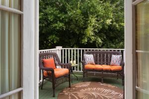 two wicker chairs with pillows sitting on a porch at Azalea Inn and Villas in Savannah