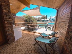 un patio con una silla, una mesa y una piscina en Studio Fran - Port Macquarie canals, en Port Macquarie