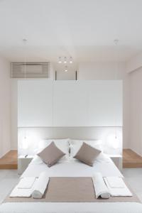 una camera bianca con un grande letto con due cuscini di Cattolica Apartments a Cattolica