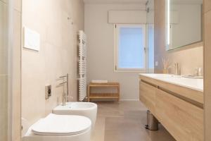 卡托利卡的住宿－Cattolica Apartments，白色的浴室设有卫生间和水槽。