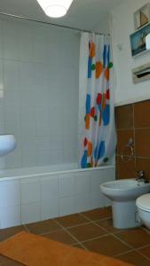 uma casa de banho com uma banheira, um WC e uma cortina de chuveiro. em Sierra Nevada Apartment em Granada