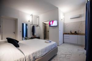 a bedroom with a bed and a tv on a wall at Domus Vittoria Siracusa in Siracusa