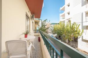 a balcony with a white chair and a table at Private Rooms Athens - Shared Bathroom in Athens