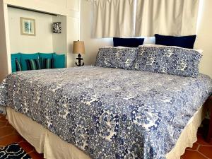 a bedroom with a bed with a blue and white comforter at Casita Blanca by FMI Rentals in Puerto Peñasco