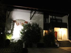 a building with a sign on the side of it at night at Hotel garni Bellevue in Bad Füssing