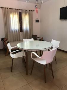 comedor con mesa y sillas blancas en Duplex Salvat en Puerto Iguazú