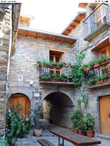 a stone building with a wooden bench in front of it at Preciosas Vistas a La Montaña, Luminoso y Acogedor in El Pueyo de Araguás