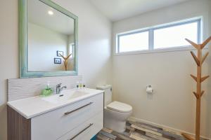 a bathroom with a sink and a toilet and a mirror at Five Palms in Kaikoura