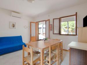 ein Wohnzimmer mit einem Tisch und einem blauen Sofa in der Unterkunft Belvilla by OYO Casa Pineta in Rosolina Mare