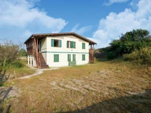 une maison sur un champ herbeux avec un bâtiment dans l'établissement Belvilla by OYO Brezza di mare, à Rosolina Mare