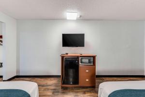 Cette chambre comprend 2 lits et une télévision murale. dans l'établissement Motel 6-Tupelo, MS - Downtown, à Tupelo