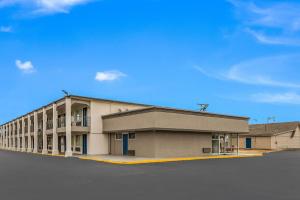 un gran edificio en un estacionamiento con un cielo azul en Motel 6-Tupelo, MS - Downtown, en Tupelo