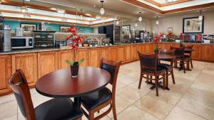 un restaurante con mesas, sillas y una barra en Best Western Plus Monahans Inn and Suites, en Monahans