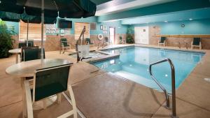 a large swimming pool with a table and an umbrella at Best Western Plus Monahans Inn and Suites in Monahans