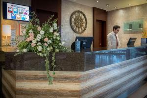 a man standing at a reception desk in a hotel lobby at Best Western Plus Hotel Konak in İzmir