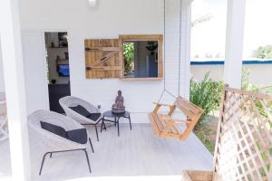 a porch with chairs and a table and a mirror at Sweety Paradise jacuzzi ,intimité zénitude et plages in Sainte-Rose