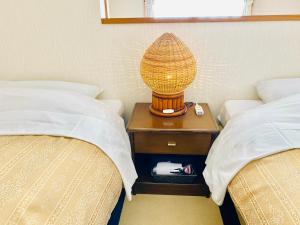 a lamp on a night stand between two beds at Villa Rengatei in Hakuba