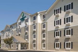 un grande edificio bianco con un cartello sopra di WoodSpring Suites Augusta Fort Eisenhower ad Augusta