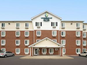 a large building with a sign on top of it at WoodSpring Suites Louisville Clarksville in Clarksville
