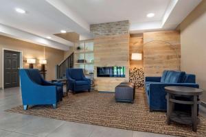 een wachtkamer met blauwe stoelen en een tafel bij Comfort Inn & Suites Millbrook-Prattville in Millbrook