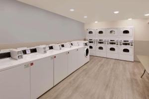 eine Waschküche mit weißen Waschmaschinen und Trocknern in der Unterkunft WoodSpring Suites Bakersfield East in Bakersfield