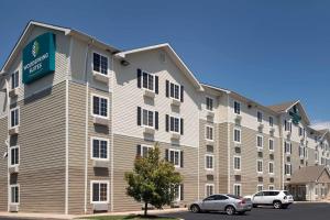 un gran edificio de apartamentos con coches aparcados en un aparcamiento en WoodSpring Suites Augusta Riverwatch, en Augusta