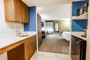 a kitchen with a sink and a bed in a room at Holiday Inn Express Indianapolis South by IHG in Indianapolis