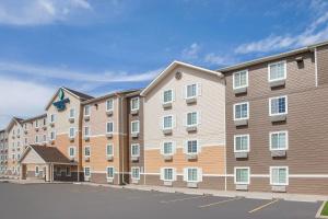 a large apartment building in a parking lot at WoodSpring Suites Sioux Falls in Sioux Falls