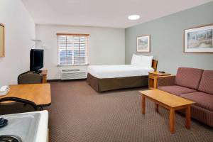 a hotel room with a bed and a couch at WoodSpring Suites Fort Wayne in Fort Wayne