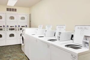 a laundry room with white washing machines and cabinets at WoodSpring Suites Fort Wayne in Fort Wayne