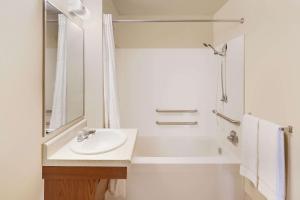 a white bathroom with a sink and a shower at WoodSpring Suites Des Moines Pleasant Hill in Pleasant Hill
