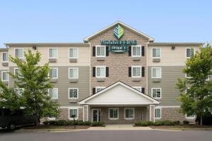a building with a sign on the front of it at WoodSpring Suites Raleigh Apex in Apex