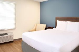 ナッシュビルにあるWoodSpring Suites Nashville Airportの大きな白いベッドと窓のある寝室