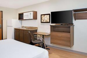 a hotel room with a bed and a desk with a tv at WoodSpring Suites Nashville Airport in Nashville