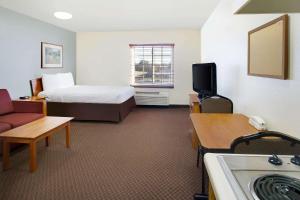 a hotel room with a bed and a television at WoodSpring Suites Baton Rouge East I-12 in Baton Rouge