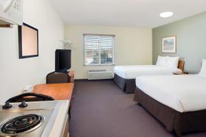 a hotel room with two beds and a stove at WoodSpring Suites Baton Rouge East I-12 in Baton Rouge