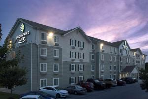 a hotel with cars parked in a parking lot at WoodSpring Suites Knoxville Airport in Alcoa