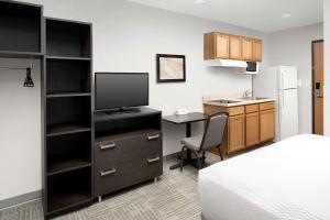 Habitación con cama y escritorio con TV. en WoodSpring Suites Murfreesboro, en Murfreesboro