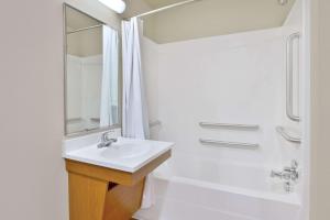a white bathroom with a sink and a shower at WoodSpring Suites Memphis East I-40 in Memphis +8 photos