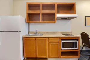 una pequeña cocina con fregadero y nevera. en WoodSpring Suites Chesapeake-Norfolk Greenbrier en Chesapeake