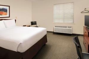 a hotel room with a bed and a television at WoodSpring Suites Waco near University in Waco