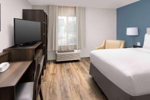 une chambre d'hôtel avec un lit et une télévision dans l'établissement WoodSpring Suites Austin South Central I-35, à Austin