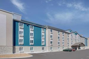 a blue and white apartment building with a parking lot at WoodSpring Suites Nashville near Rivergate in Goodlettsville