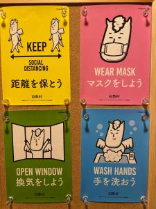 a group of signs in a bathroom with a cat on the bed at Villa Rengatei in Hakuba