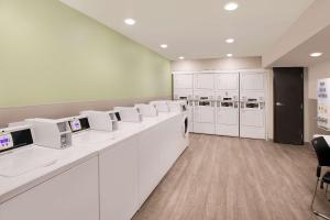 a waiting room with white counters and white appliances at WoodSpring Suites Nashville near Rivergate in Goodlettsville