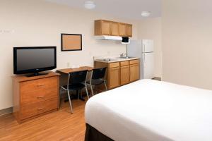 a hotel room with a bed and a desk with a television at WoodSpring Suites Clarksville Ft. Campbell in Clarksville