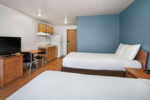 a hotel room with two beds and a flat screen tv at WoodSpring Suites Clarksville Ft. Campbell in Clarksville